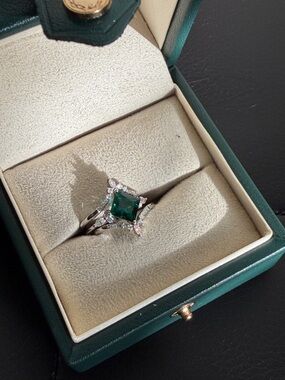 Emerald surrounded by moissanite in sterling silver.
